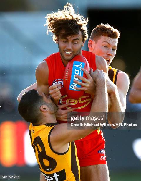 Lachie Weller of the Suns is tackled by Paul Puopolo and Tim O'Brien of the Hawks during the 2018 AFL round 14 match between the Hawthorn Hawks and...