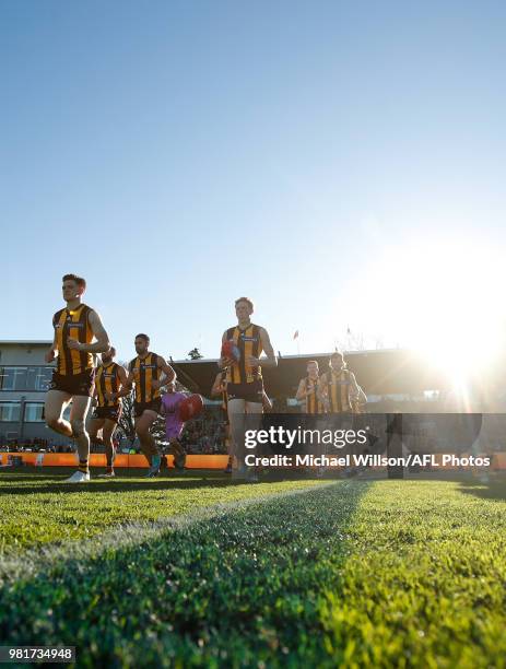 The Hawks run onto the field during the 2018 AFL round 14 match between the Hawthorn Hawks and the Gold Coast Suns at UTAS Stadium on June 23, 2018...