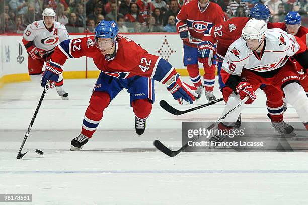 Dominic Moore of the Montreal Canadiens skates with the puck in front of Erik Cole of the Carolina Hurricanes during the NHL game on March 31, 2010...