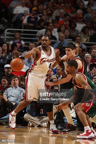 Leon Powe of the Cleveland Cavaliers passes against Ersan Ilyasova and Charlie Bell of the Milwaukee Bucks on March 31, 2010 at Quicken Loans Arena...