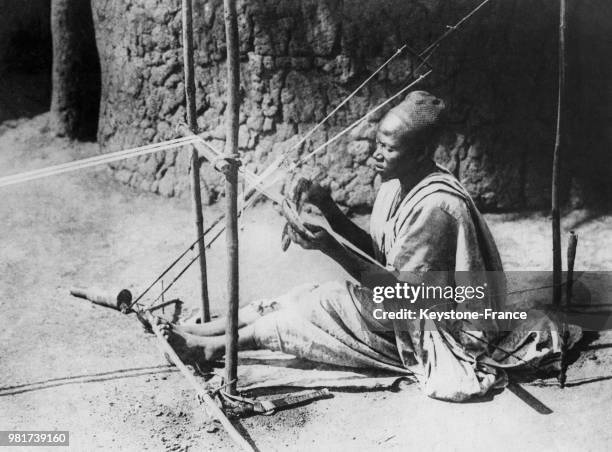 Homme tissant sur un marché au Cameroun.