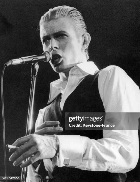 Le 6 mai 1976, à l'Empire Pool de Wembley à Londres en Angleterre au Royaume-Uni, la pop-star anglaise David Bowie se produit sur scène - Il vient...