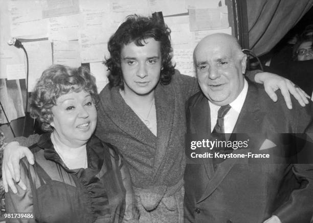 Le 18 janvier 1973, à l'Olympia de Paris en France, le chanteur français Michel Sardou pose entouré de ses parents, les comédiens Jackie et Fernand...