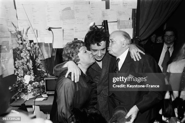 Le 18 janvier 1973, à l'Olympia de Paris en France, le chanteur français Michel Sardou pose entouré de ses parents, les comédiens Jackie et Fernand...