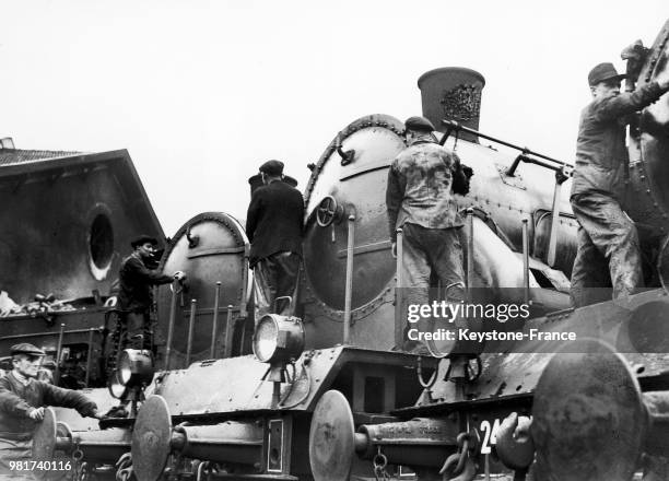 Entretien des locomotives à vapeur 230 de la compagnie du chemin de fer Paris-Lyon-Méditerranée au dépôt de la gare de Lyon à Paris en France, le 6...