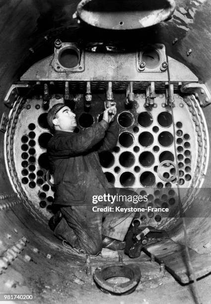 Réparation de la chaudière d'une locomotive de la compagnie du chemin de fer Paris-Lyon-Méditerranée au dépôt de Nevers en France, en 1934.