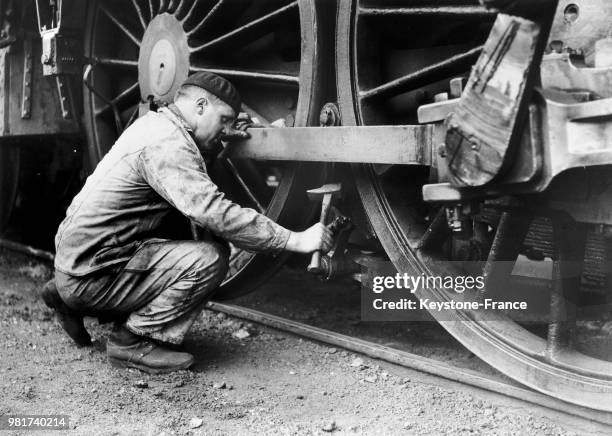 Vérification de l'embiellage d'une locomotive à vapeur de la compagnie du chemin de fer Paris-Lyon-Méditerranée , en France, en 1938.