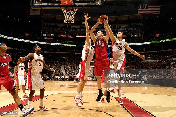 Chris Kaman of the Los Angeles Clippers battles hard for the lay in against Hedo Turkoglu of the Toronto Raptors during a game on March 31, 2010 at...