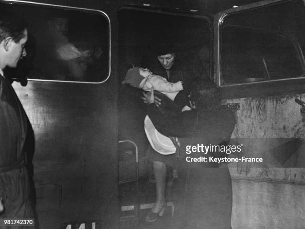Les civils anglais sont rapatriés de Palestine : une mère et son enfant descendent du car qui les amenés de l'aéroport d'Orly à l'hôtel Petrograd à...