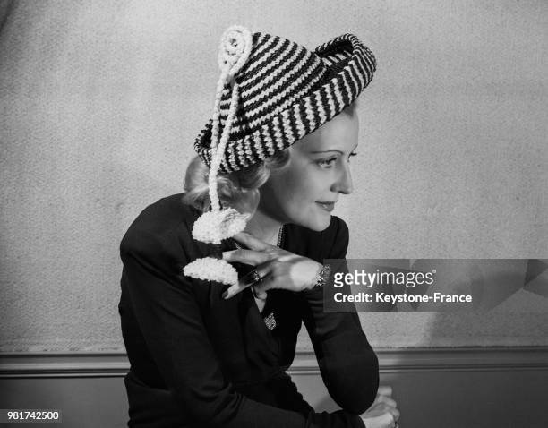 Mannequin portant le chapeau 'Liseron blanc' bleu marine et blanc de la maison de mode 'Marthe' à Paris en France, le 17 février 1947.