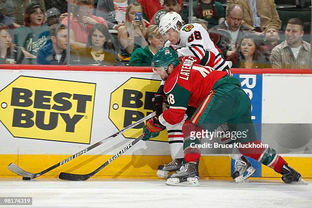 Guillaume Latendresse of the Minnesota Wild and Patrick Kane of the Chicago Blackhawks battle for control of the puck along the boards during the...
