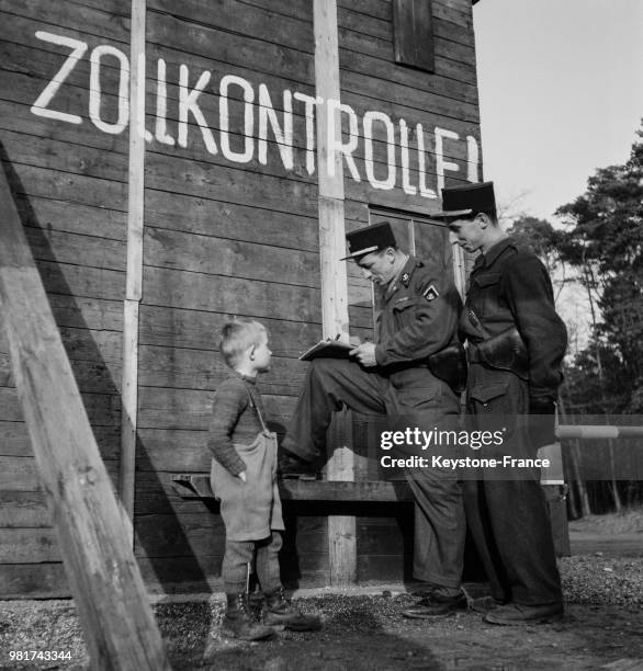 Les douaniers sarrois avec un enfant allemand , en France, le 26 mars 1947.