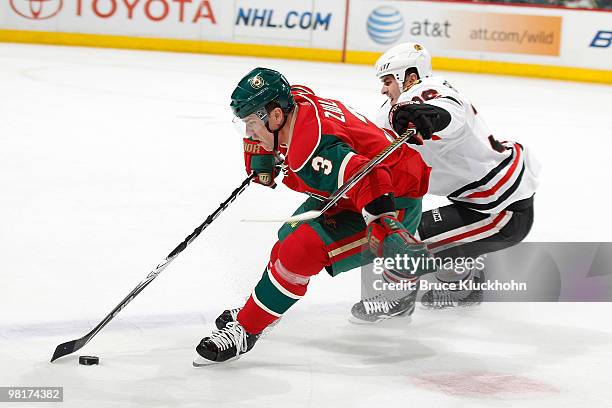 Marek Zidlicky of the Minnesota Wild skates with the puck while Dave Bolland of the Chicago Blackhawks defends during the game at the Xcel Energy...