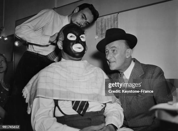 André Randall examine le maquillage de Ray Ventura sur le tournage du film 'Mademoiselle s'amuse' réalisé par Jean Boyer aux studios de cinéma à...