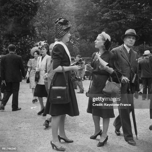 Jeunes femmes élégantes lors d'un grand prix à l'hippodrome de Longchamp à Paris en France, en 1946.