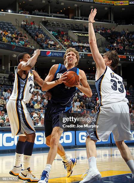 Dirk Nowitzki of the Dallas Mavericks drives between Rudy Gay and Marc Gasol of the Memphis Grizzlies on March 31, 2010 at FedExForum in Memphis,...
