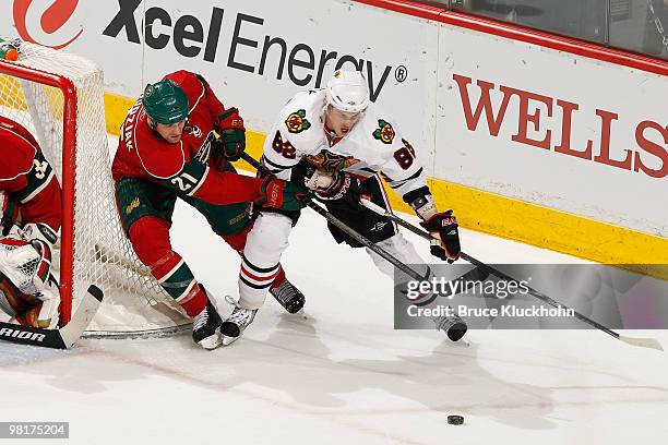 Tomas Kopecky of the Chicago Blackhawks skates with the puck with Kyle Brodziak of the Minnesota Wild defending during the game at the Xcel Energy...