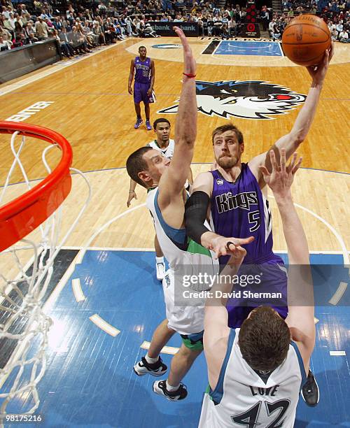 Andres Nocioni of the Sacramento Kings goes to the basket against Sasha Pavlovic, Kevin Love and Wayne Ellington of the Minnesota Timberwolves during...