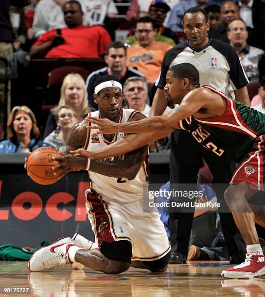 LeBron James of the Cleveland Cavaliers passes from his knees against Charlie Bell of the Milwaukee Bucks on March 31, 2010 at The Quicken Loans...
