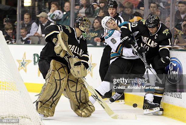 Goaltender Marty Turco of the Dallas Stars plays the puck against Joe Pavelski of the San Jose Sharks and Brenden Morrow at American Airlines Center...