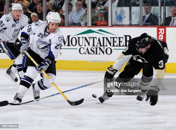 Martin St Louis of the Tampa Bay Lightning moves the puck past Alex Goligoski of the Pittsburgh Penguins on March 31, 2010 at Mellon Arena in...