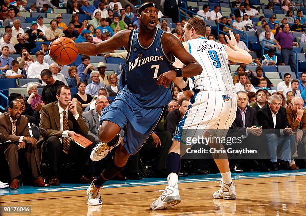 Andray Blatche of the Washington Wizards drives the ball around Darius Songaila of the New Orleans Hornets at New Orleans Arena on March 31, 2010 in...