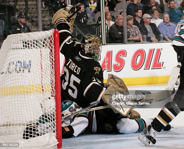 Marty Turco of the Dallas Stars gets tangled up against Jamie McGinn of the San Jose Sharks on March 31, 2010 at the American Airlines Center in...