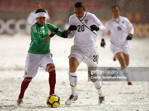 Abby Wambach of the United States battles against Leticia Villalpoado of Mexico during the international friendly match between the United States and...