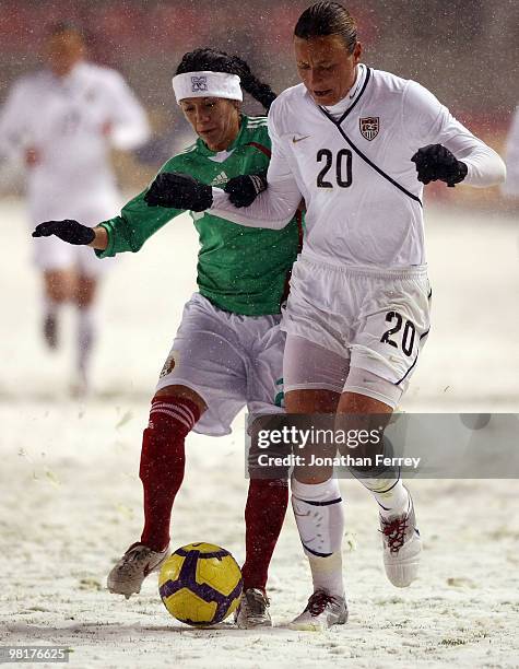 Abby Wambach of the United States battles against Leticia Villalpoado of Mexico during the international friendly match between the United States and...