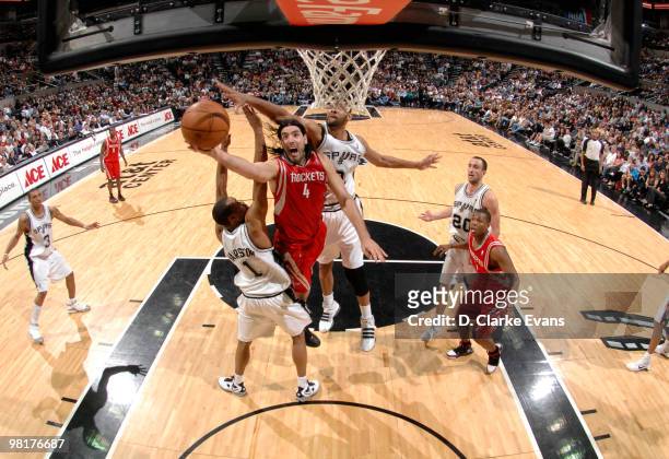 Luis Scola of the Houston Rockets shoots against Tim Duncan and Malik Hairston of the San Antonio Spurs on March 31, 2010 at the AT&T Center in San...