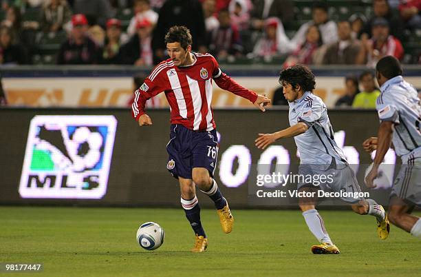 Sacha Kljestan of Chivas USA looks to make a pass play under defensive pressure from Kosuke Kimura of the Colorado Rapids at the Home Depot Center on...