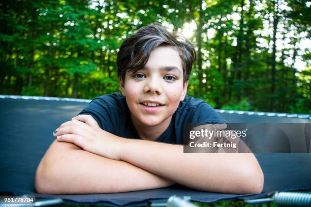 handsome 12-jarige op een trampoline - 12 13 jaar stockfoto's en -beelden