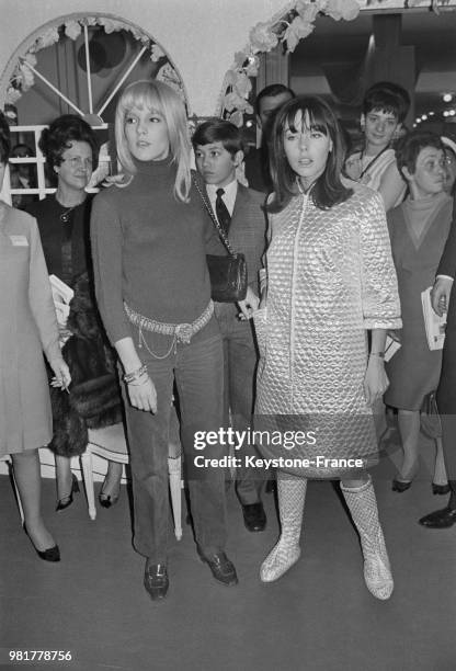 Avec un mannequin portant un modèle de robe de chambre avec bottes assorties, Sylvie Vartan présente sa Collection Printemps/Eté 1967 au salon de la...