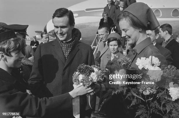 Une hôtesse du Bourget offre un bouquet de fleurs à la princesse Margrethe de Danemark arrivée avec son fiancé le comte Henri de Laborde de Monpezat...