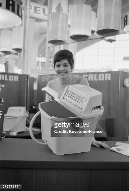 Stand du salon des arts ménagers au CNIT de la Défense presentation d une machine a laver Calor , à Puteaux, en 1967, dans les Hauts-de-Seine, France.