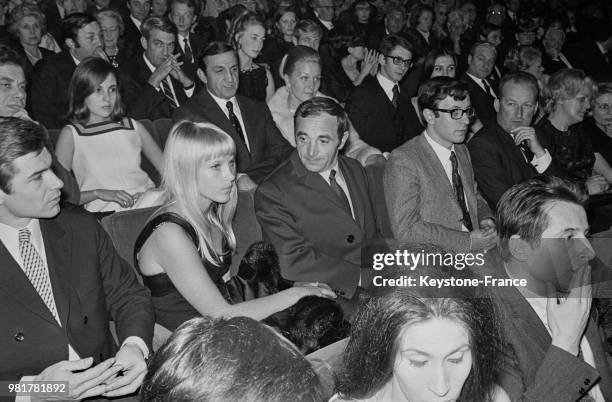 Le chanteur français Charles Aznavour et son épouse Ulla dans le public de l'avant-première du film 'Les Demoiselles de Rochefort' au cinéma...