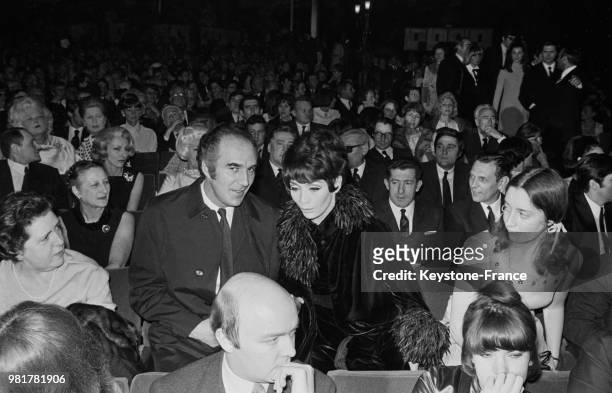 Michel Piccoli et Juliette Gréco dans le public de l'avant-première du film 'Les Demoiselles de Rochefort' au cinéma Normandie, à Paris, en 1967,...