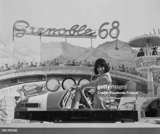 Lise Sarian assise dans un bobsleigh dans le manège 'Grenoble 68' à la Foire du Trône sur la pelouse de Reuilly à Paris en France, le 17 mars 1967.