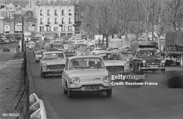 Au vu du temps clément, les automobilistes quittent la capitale en direction de l'autoroute de l'ouest à Paris en France, le 24 mars 1967.