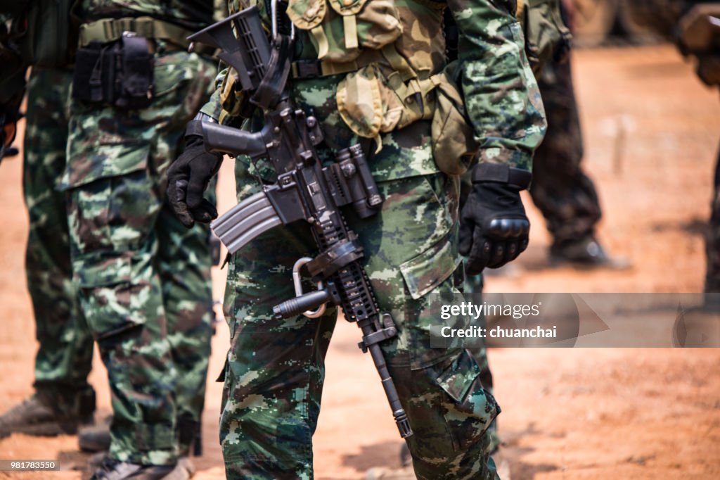 Midsection Of Army Soldiers With Rifle