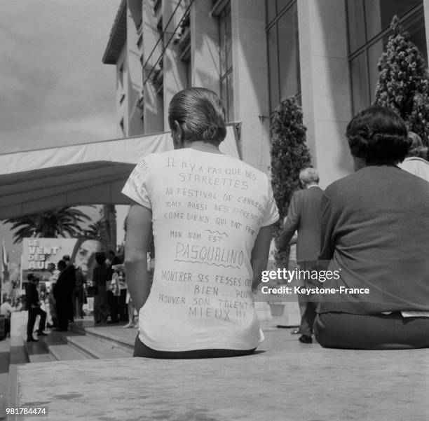 Apprenti comédien assis sur les marches du palais des festivals lors du festival international du film à Cannes en France, en 1967.