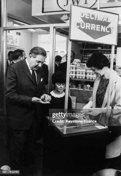 Le chancelier de l'Échiquier James Callaghan et son épouse Audrey payant avec de la monnaie décimale, spécialement frappée pour la circonstance et...