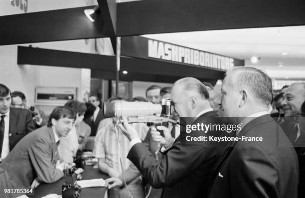 Le premier ministre Georges Pompidou examinant un appareil photographique sur le stand soviétique à la Foire de Paris à Paris en France, le 20 mai...