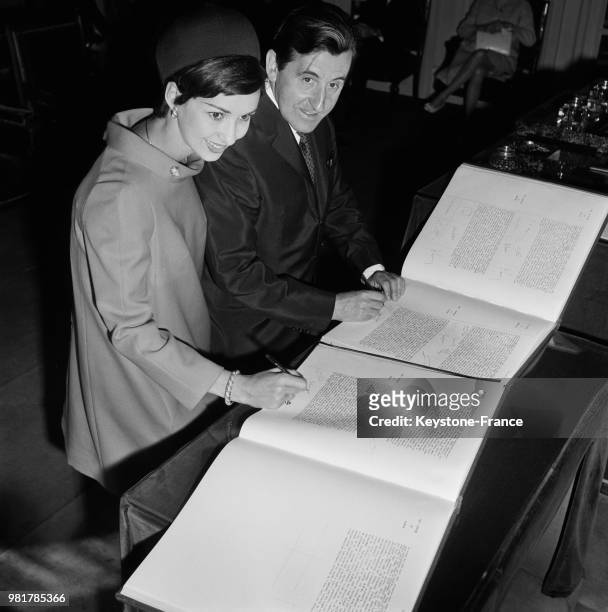 Jean Lefebvre et Yori Bertin signant le registre de l'état civil lors de leur mariage à la mairie de Neuilly-sur-Seine en France, le 20 mai 1967.