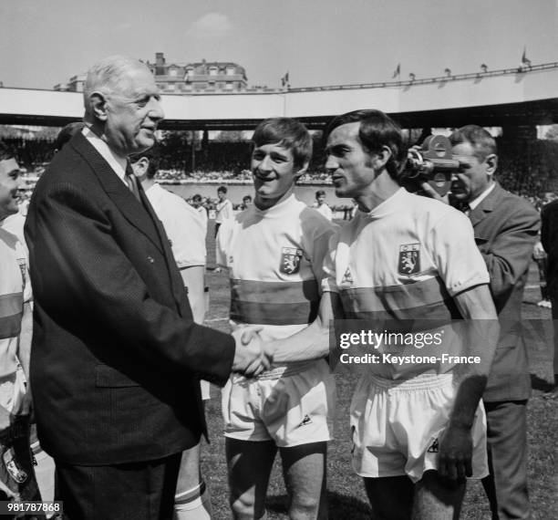 Le général Charles de Gaulle serrant la main des joueurs de l'Olympique lyonnais qui viennent de remporter la finale de la coupe de France de...