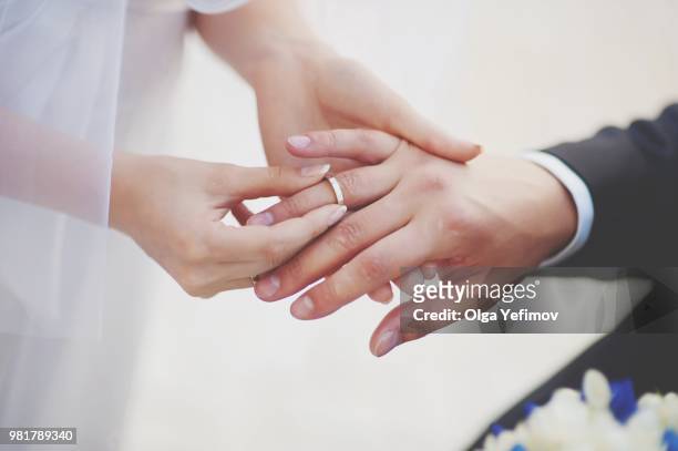 midsection of couple exchanging wedding ring - cerimonia di nozze foto e immagini stock