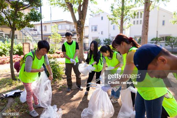 group of volunteers cleaning public park in tokyo - volunteers cleaning public park stock pictures, royalty-free photos & images