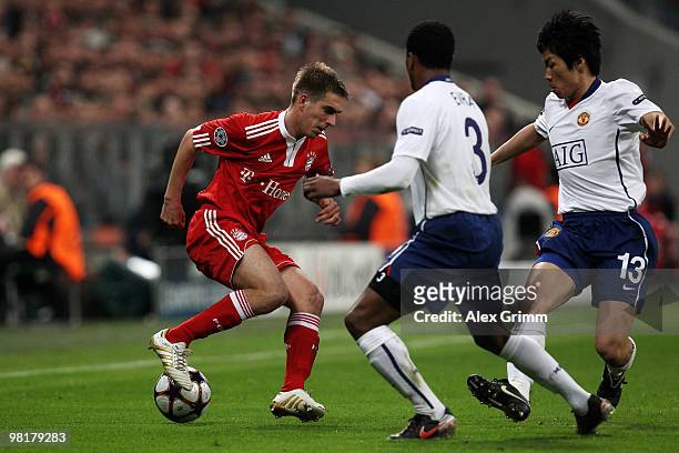 Philipp Lahm of Muenchen is challenged by Patrice Evra and Ji Sung Park of Manchester during the UEFA Champions League quarter final first leg match...