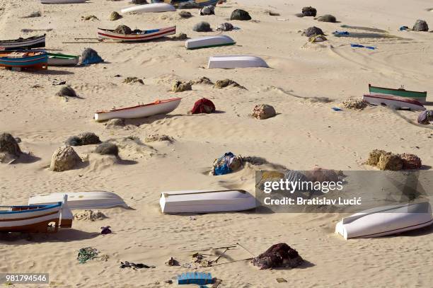 beach covered in boats and fishing nets in hammamet, tunisia - hammamet beach stock pictures, royalty-free photos & images