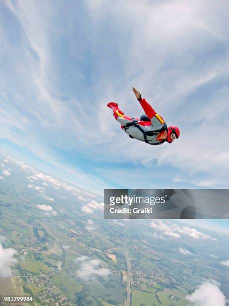 high speed parachutist conducting a tracking towards the earth. - skydive stock pictures, royalty-free photos & images